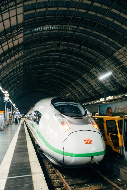 a train pulling into a train station next to a platform, 🚿🗝📝, hyperspeed, white, indoor picture