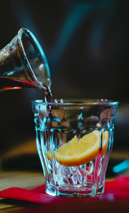 a person pouring a drink into a glass, a screenshot, by Robbie Trevino, pexels, renaissance, lemon, red wine, old fashioned, thumbnail