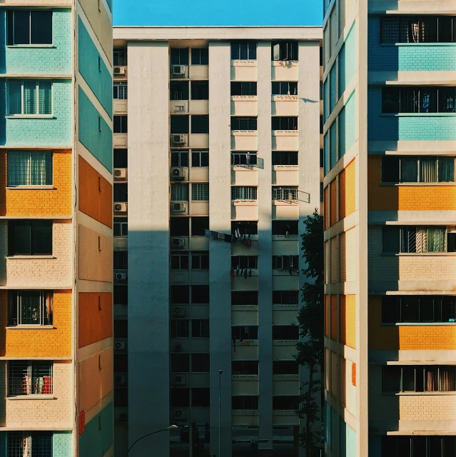 a couple of tall buildings next to each other, a photo, unsplash contest winner, hyperrealism, chartreuse and orange and cyan, concrete housing, shot with hasselblade camera, multicolored