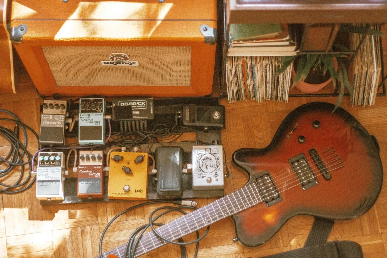 a guitar sitting on top of a hard wood floor, unsplash, old experimentation cabinet, thievery equipment, hippie pad, currents