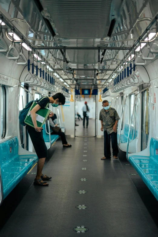 a couple of people standing next to each other on a train, singapore, 8 k cleaning future, cyan and green, empty