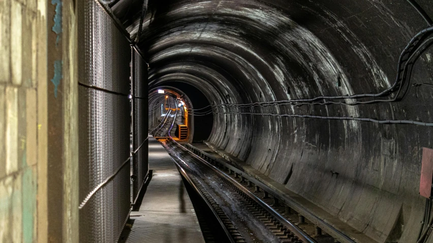 a train traveling through a tunnel next to a train track, a portrait, unsplash, underground bunker, realistic »