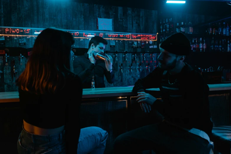 a man smoking a cigarette next to a woman sitting at a bar, inspired by Elsa Bleda, pexels contest winner, blue neon light, 3 actors on stage, standing in a cantina, moody grindhouse