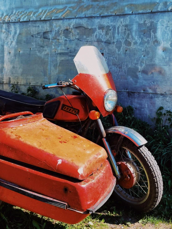 a red motorcycle parked next to a blue wall, an album cover, by Filip Hodas, photorealism, 1972 soviet, scratches on photo, orange, instagram story