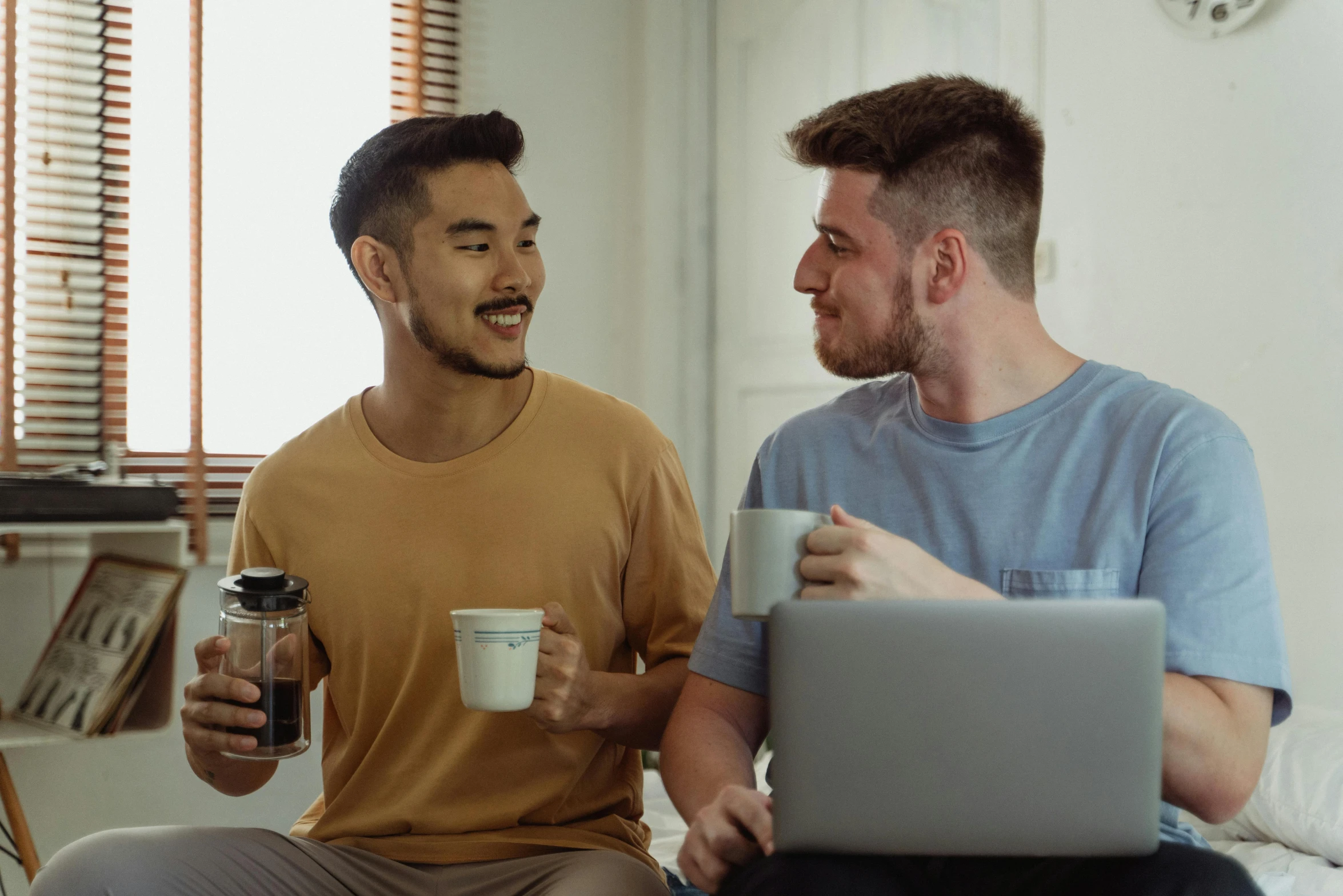 a couple of men sitting on top of a bed next to each other, trending on pexels, aussie baristas, avatar image, in meeting together, background image