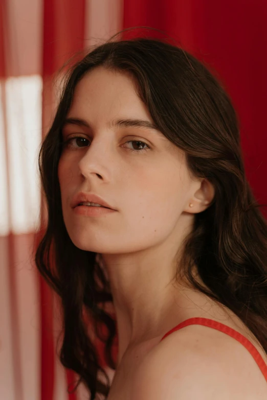 a woman standing in front of a red curtain, photorealism, beautiful cheekbones, cynthwave, press shot, laure lipton