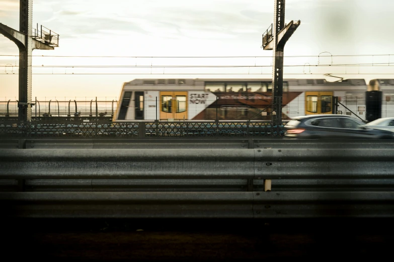 cars are driving down the highway as a train goes by