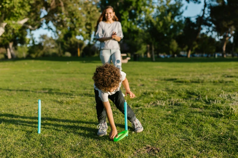 a woman and a child playing a game of frisbee, pexels contest winner, using a spade, a green, a handsome, gaming