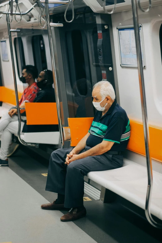 a man wearing a face mask sitting on a train, by Joze Ciuha, pexels contest winner, hyperrealism, two old people, orange line, mrt, game ready