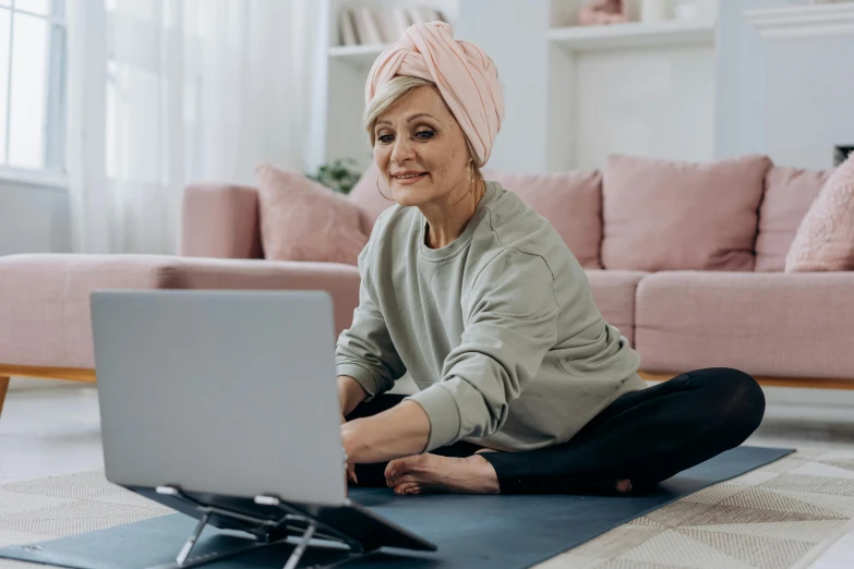 a woman sitting on a yoga mat using a laptop, older woman, youtube thumbnail, knees upturned, avatar image