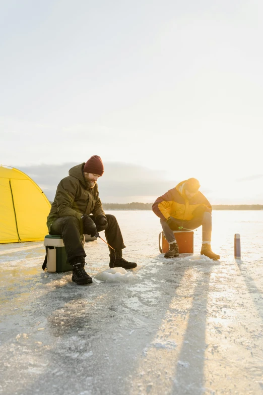 a couple of people sitting on top of a frozen lake, camping, yellow, booze, arctic fish