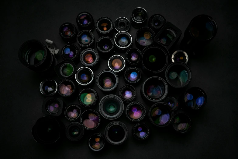 a bunch of camera lenses laying on top of each other, a microscopic photo, unsplash, art photography, on black background, many eyes, rolleiflex, lense flare