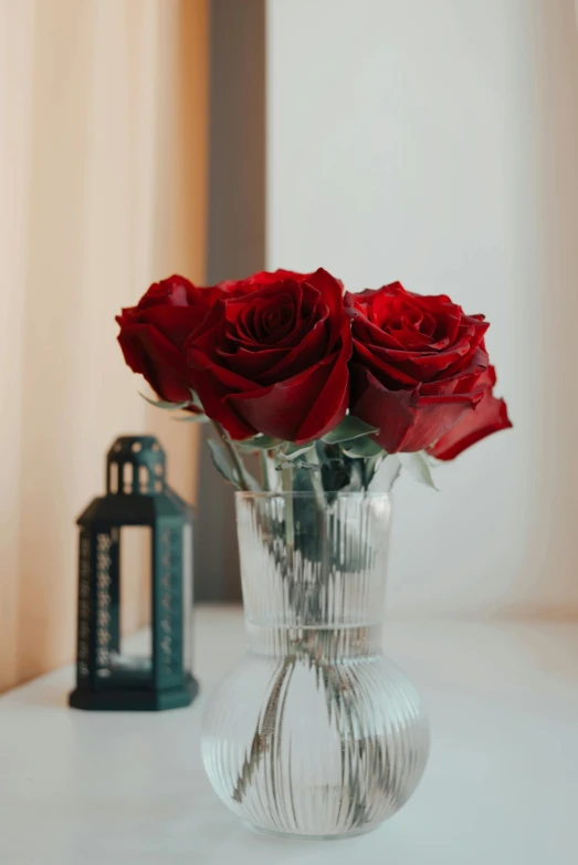 three red roses are sitting in a clear glass vase