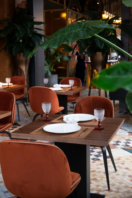 a restaurant with tables and chairs covered in orange colored velvet