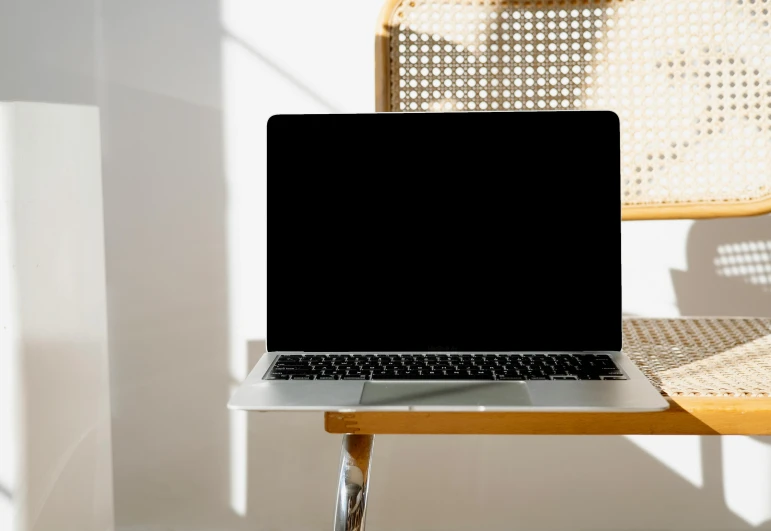 a laptop computer sitting on top of a wooden table, pexels, panel of black, sitting in an empty white room, casey cooke, brightly-lit