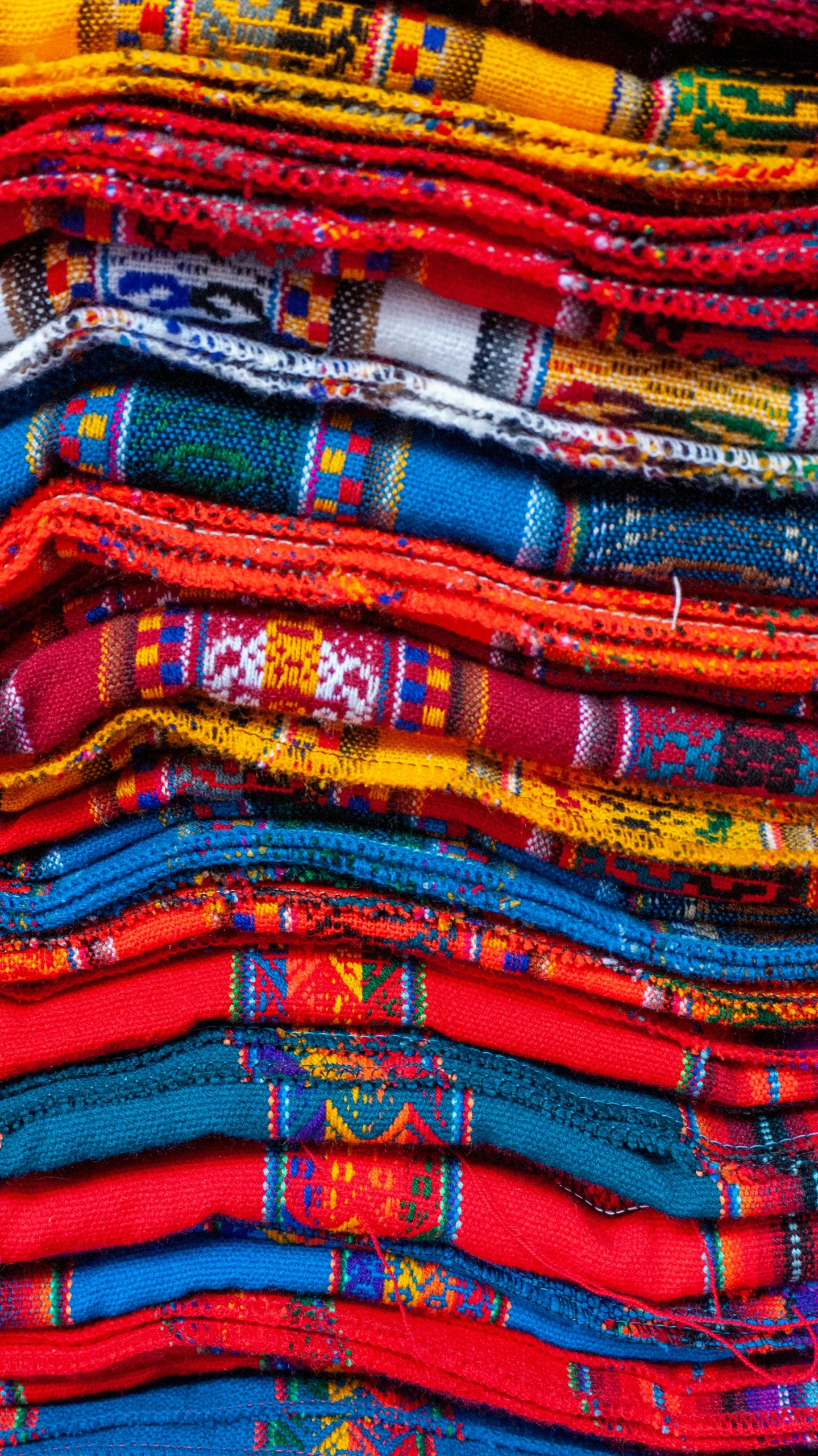 a pile of colorful fabrics stacked on top of each other, by Alice Mason, trending on unsplash, peru, intarsia, instagram post, brand colours are red and blue