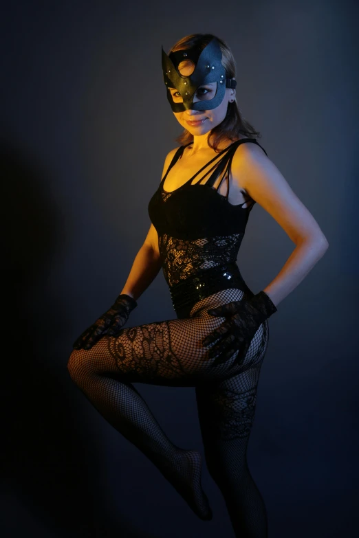 a woman in a black dress and a mask, inspired by Hans Erni, art photography, dark blue leotard costume, tease, catwoman, dressed in a lacy