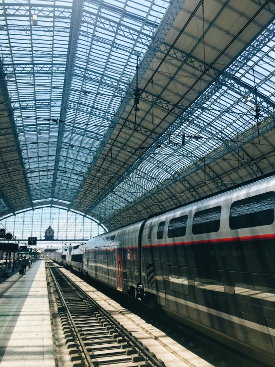 a large long train on a steel track, by Tom Wänerstrand, pexels contest winner, ornate french architecture, 2 5 6 x 2 5 6 pixels, 🚿🗝📝, bright daylight indoor photo