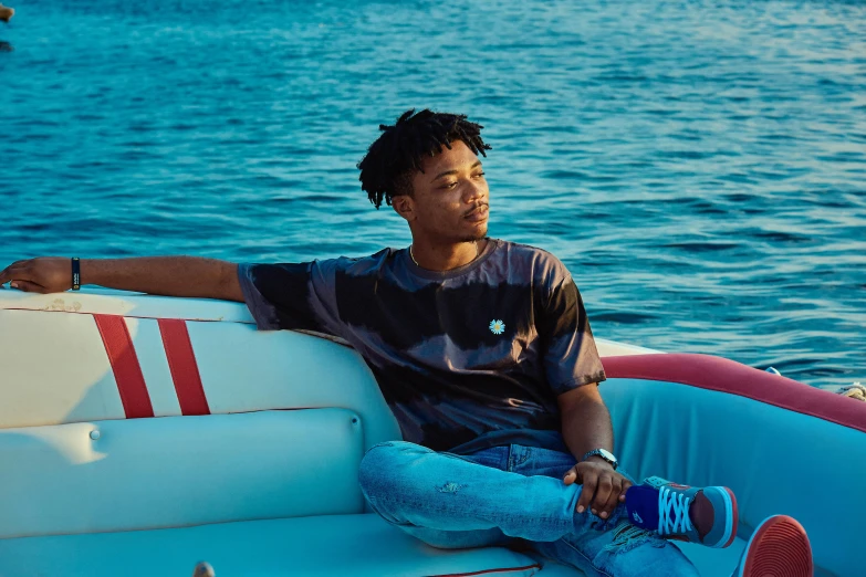 a man sitting on top of a boat near the water