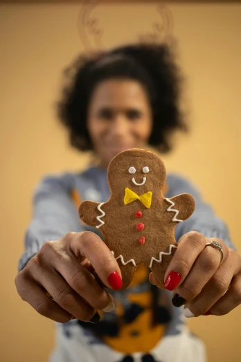 a close up of a person holding a gingerbread, grace jones, shot with premium dslr camera, essence, small