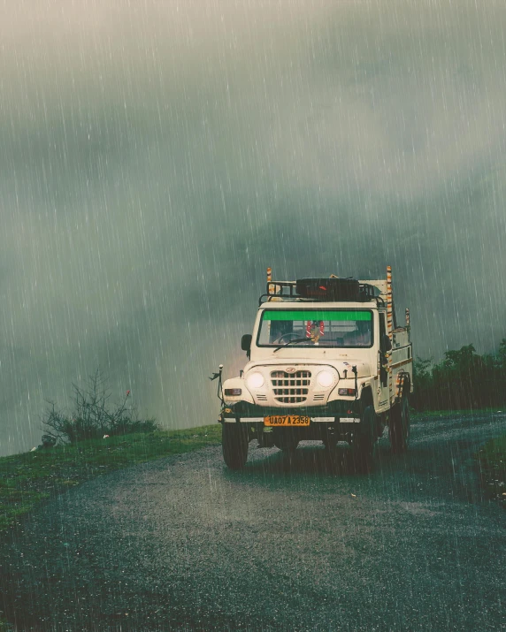 a vehicle driving down a road with rain on it