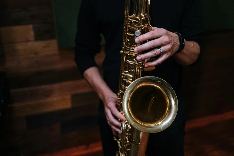 a man holding his instrument in one hand and a wooden floor