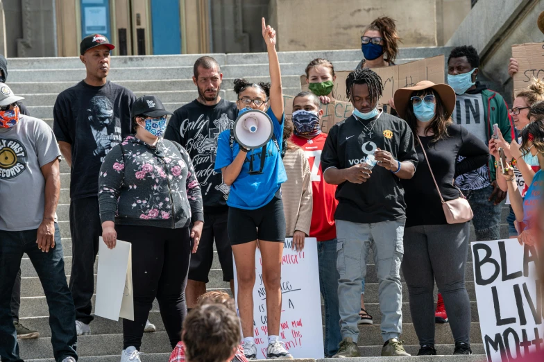 a group of people standing on the steps of a building, protest, alexis franklin, light skin, giving a speech