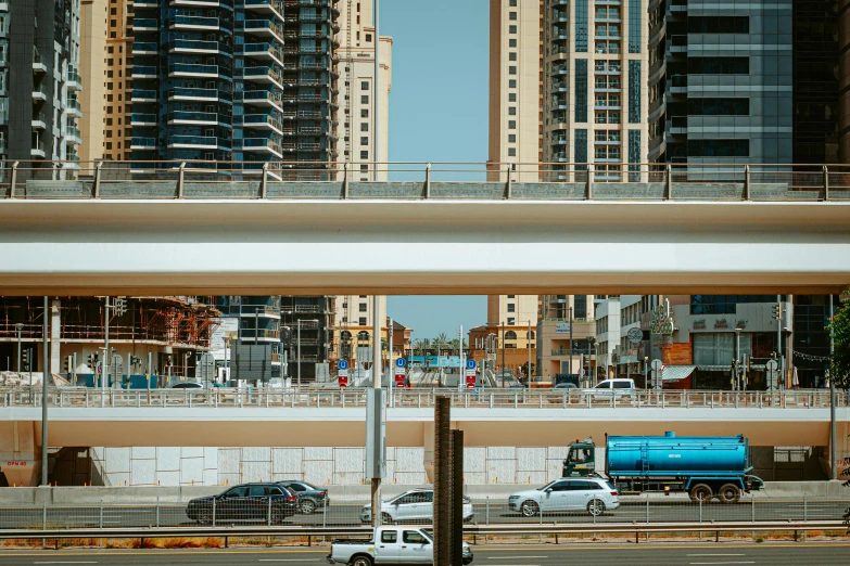 some cars are stopped at a street under an overpass