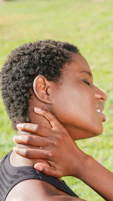the woman with a neck pain in her neck has one hand on her shoulder