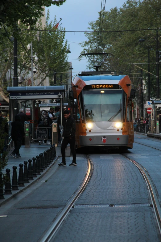 a public transit bus on a city street, by Niko Henrichon, happening, trams ) ) ), orange line, nice lighting, north melbourne street