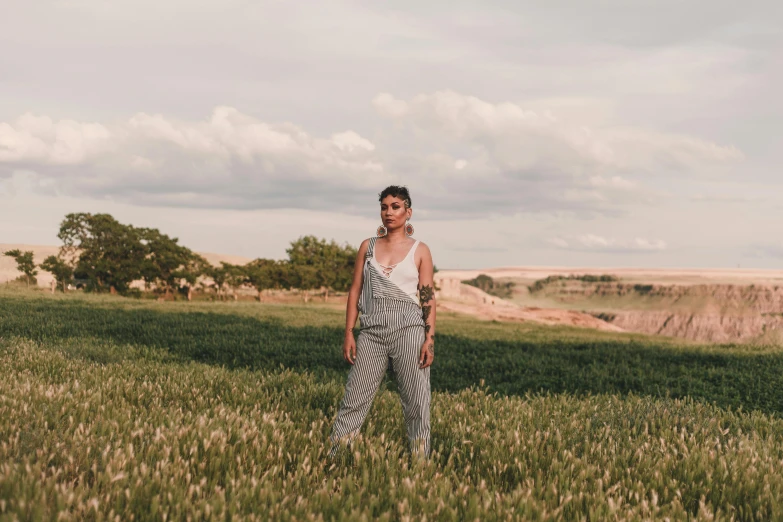 a woman wearing a striped dress standing in a field