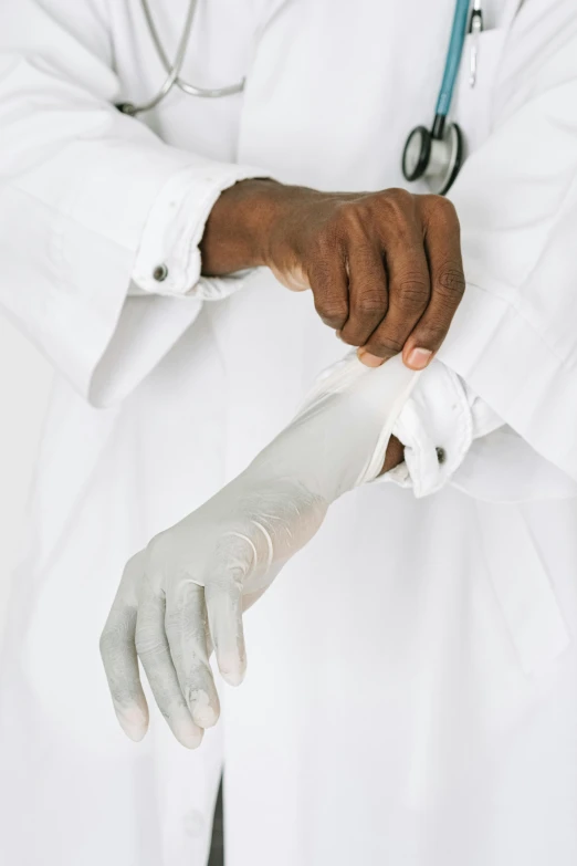 a doctor putting a bandage on a patient's arm, an album cover, inspired by Dr. Atl, pexels, romanticism, white and silver, african american, labcoat, covered in transparent cloth