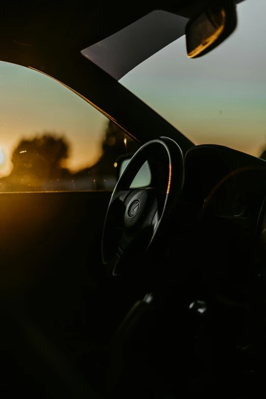 the inside of a car with the sun going down