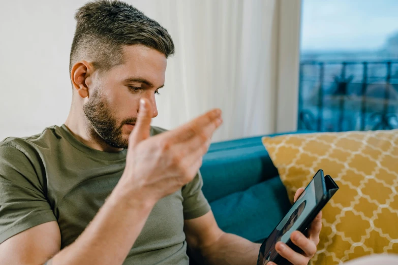 a man sitting on a couch using a tablet computer, a photo, trending on pexels, giving the middle finger, mobile game, profile picture 1024px, cleary see face