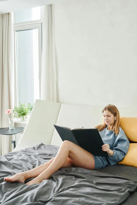 a woman sitting on a bed using a laptop, pexels contest winner, analytical art, wearing nanotech honeycomb robe, in a chill position, sleek design, reading