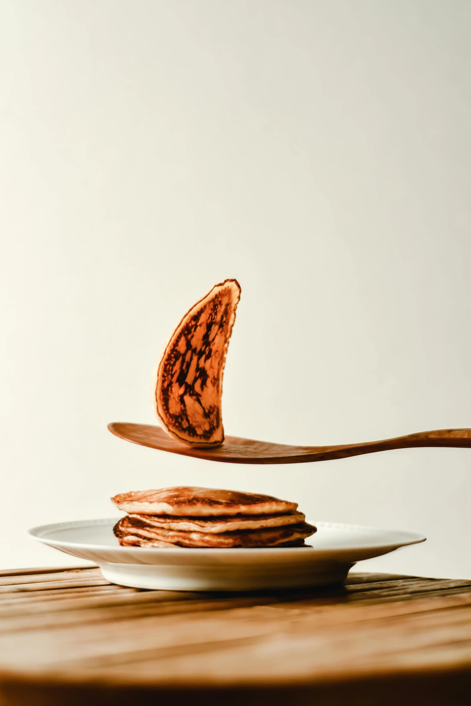 a plate with three pancakes and a erfly on top