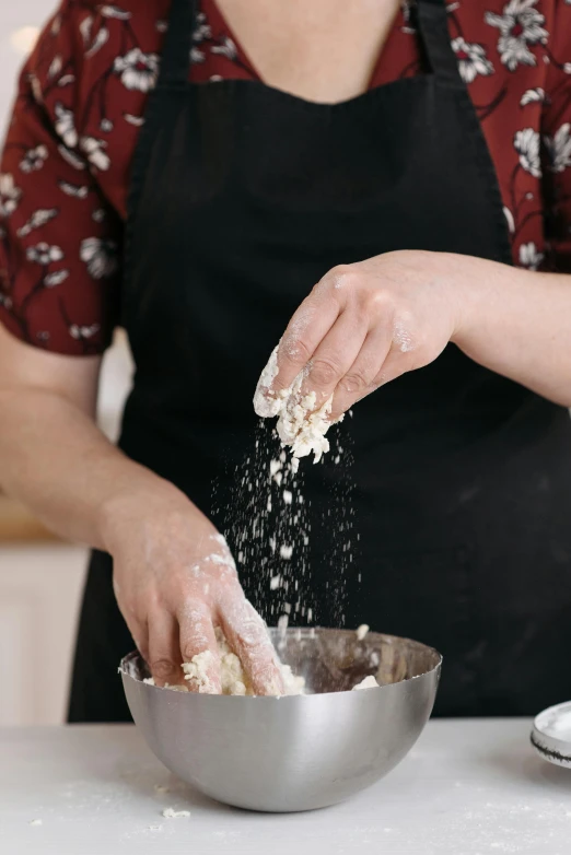a woman in an apron sprinkles flour into a bowl, a portrait, trending on pexels, square, rebecca sugar, hands, chinese