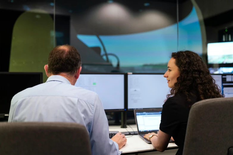 a couple of people that are sitting in front of a computer, aircraft, lachlan bailey, simulation, technical environment