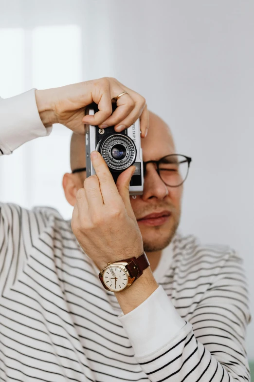 a man taking a picture of himself with a camera, hypermodernism, wearing black rimmed glasses, 2019 trending photo, professional product shot, ( ( dieter rams ) )