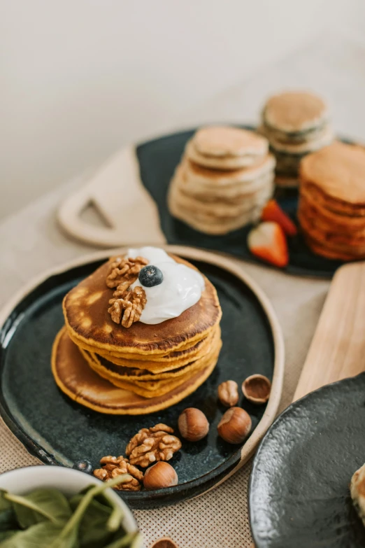 a stack of pancakes sitting on top of a black plate, unsplash, breakfast buffet, autumn, melbourne, thumbnail