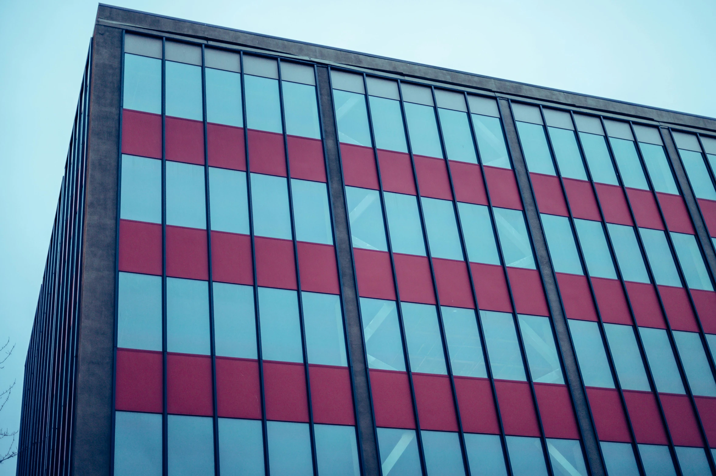 a red and black building with lots of windows, unsplash, modernism, red blue, vinyl on glazing, red stripe, commercial