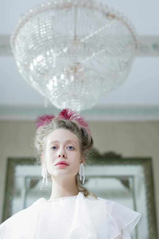 a woman in a white dress standing in front of a chandelier, inspired by Adélaïde Labille-Guiard, unsplash, rococo, pink crystal mohawk, 3 / 4 view portrait, portrait of nordic girl, high resolution photo