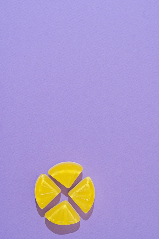 a yellow piece of fruit sitting on top of a purple surface, gummy candies, listing image, arcs, a high angle shot