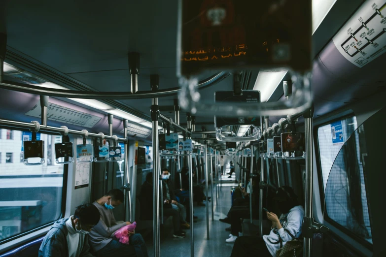 a group of people sitting next to each other on a train, by Alejandro Obregón, pexels contest winner, infinitely long corridors, inside an dystopian, seoul, carriage full of computers