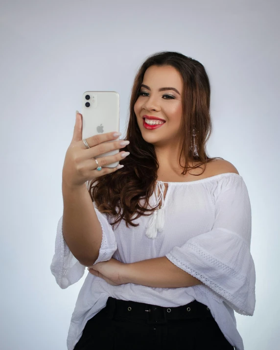 a woman taking a selfie with her cell phone, trending on pexels, tachisme, dressed in white, non binary model, studio photo, blanca alvarez