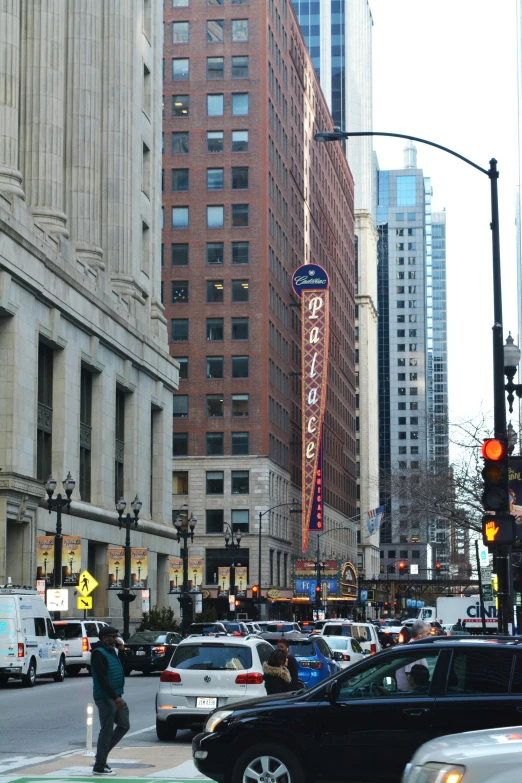 cars driving down the street near tall buildings