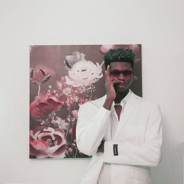 a man in a white suit talking on a cell phone, an album cover, inspired by Paul Georges, pexels contest winner, serial art, 2 1 savage, tall flowers, photo of a model, in suit with black glasses