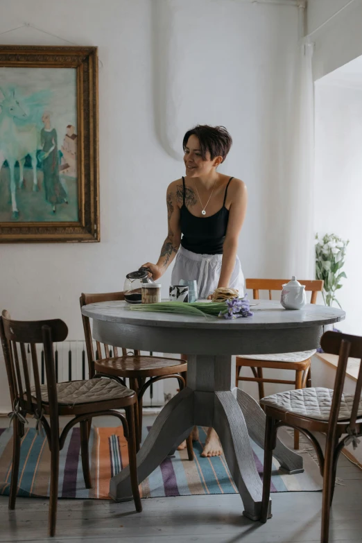 a woman standing near a table in a living area