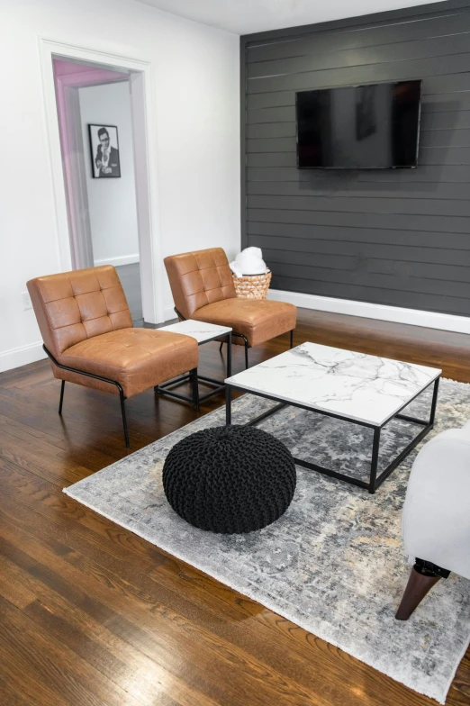 a living room with chairs, a coffee table and a television