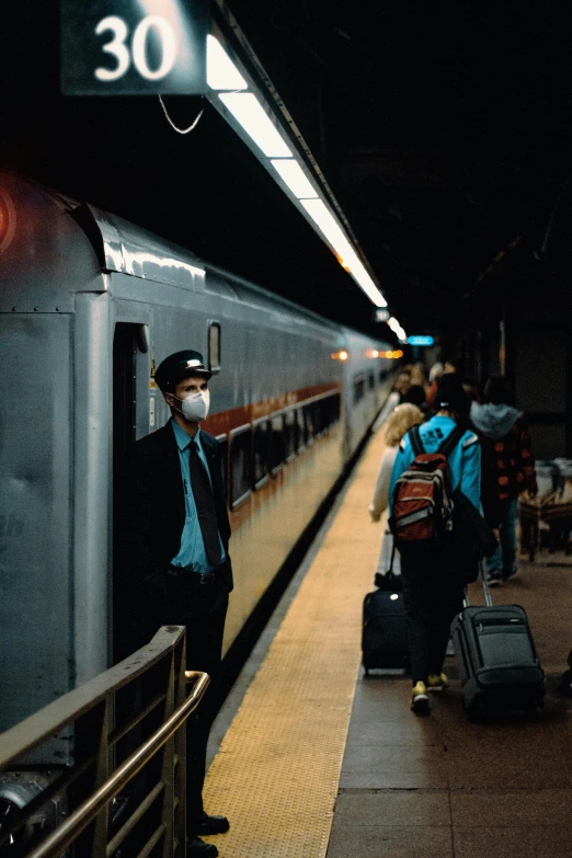 there are people in the train station waiting to board